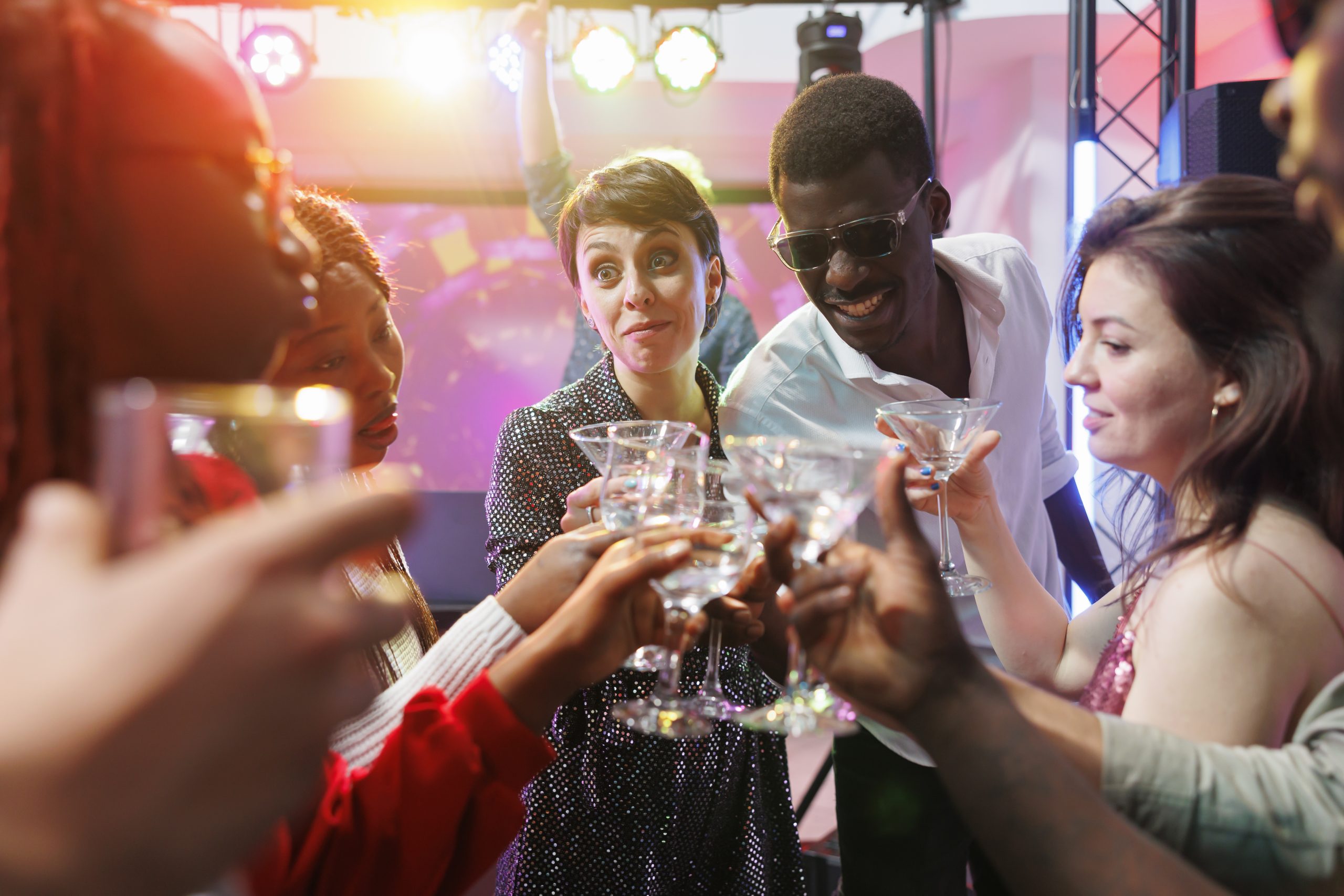 Clubbers clinking glasses at party